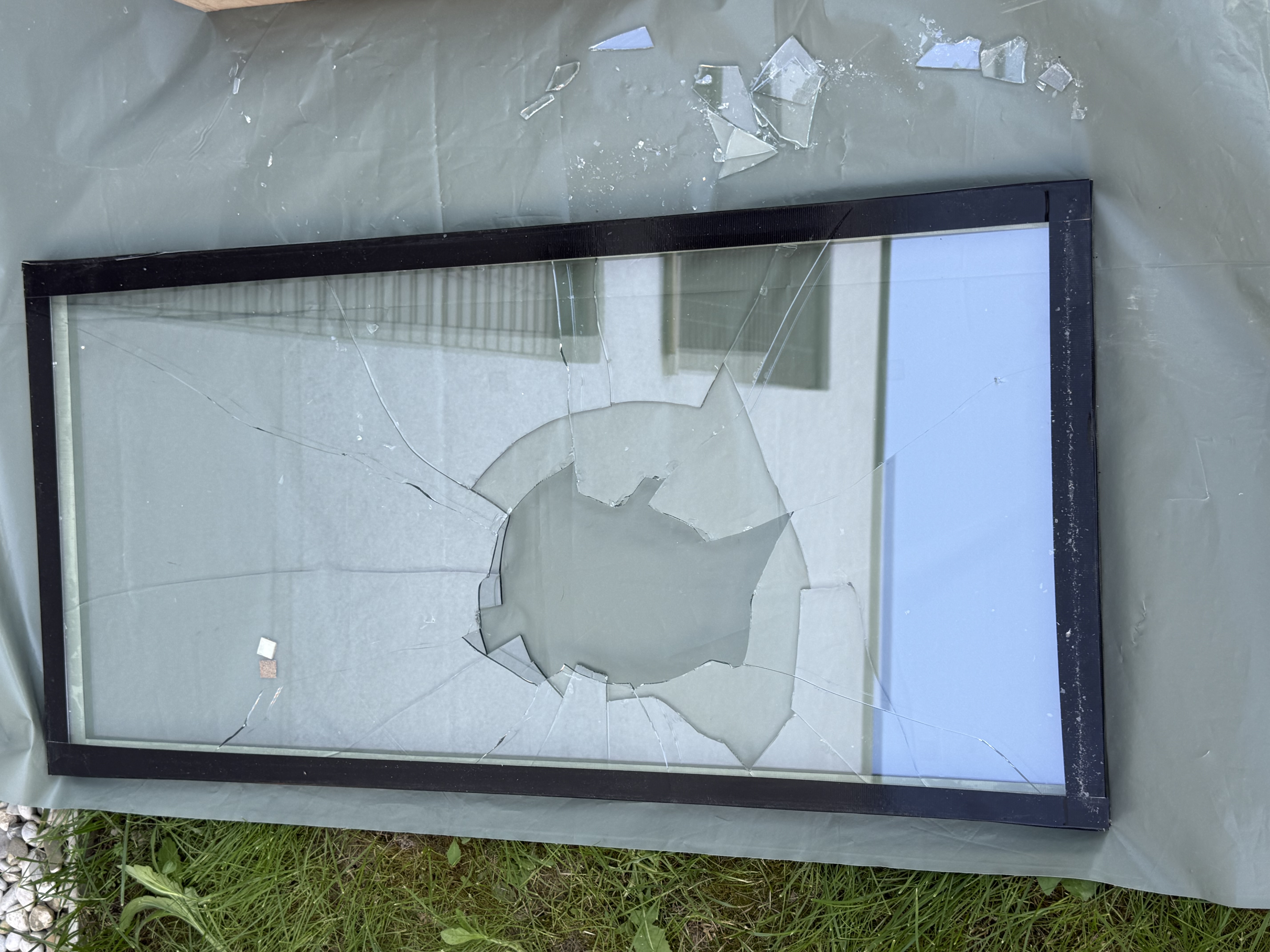 Plain glass shattered after impact — ballistic test sample