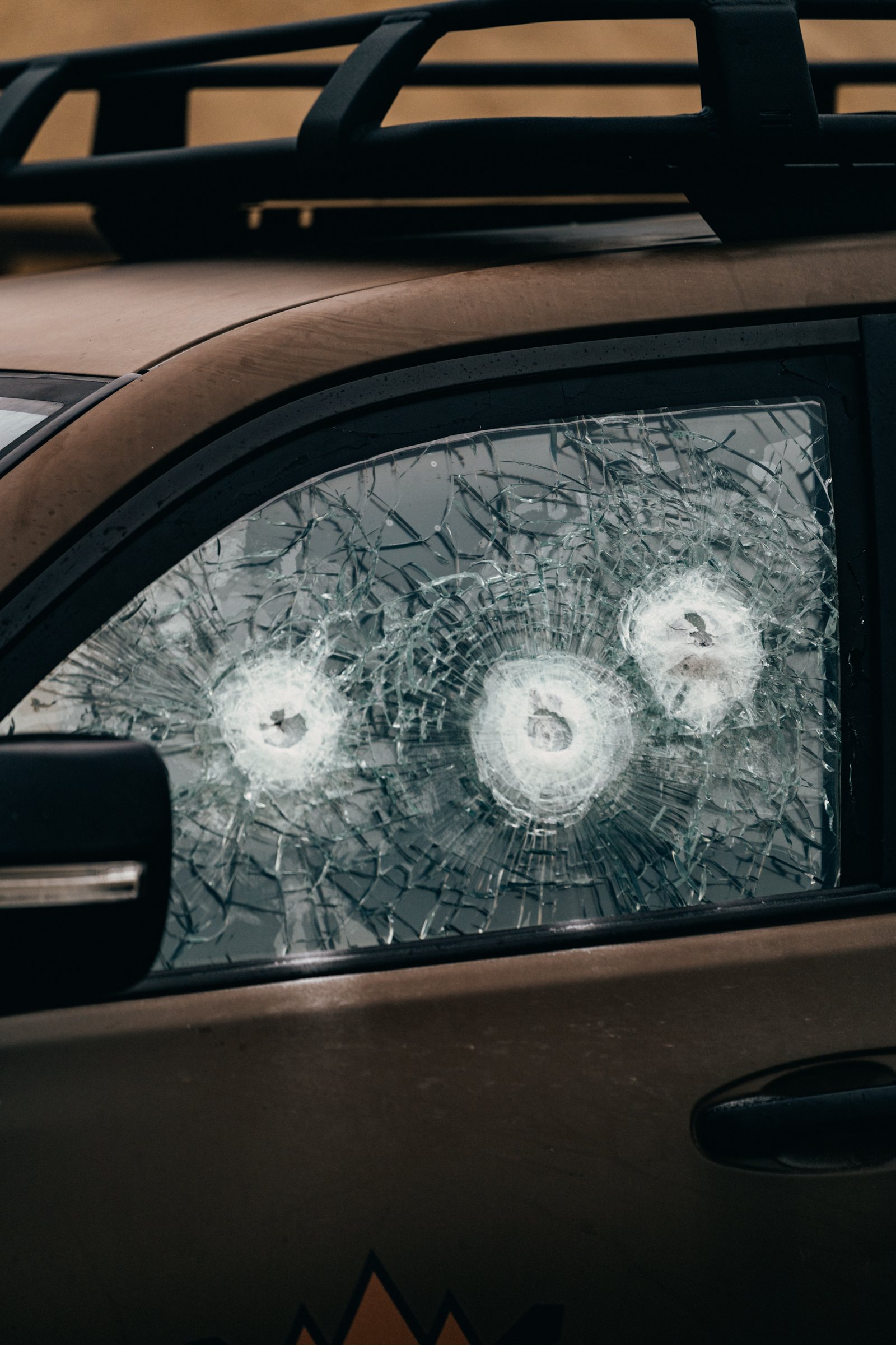 Fortis-protected vehicle window — three rounds stopped in the ballistic glass